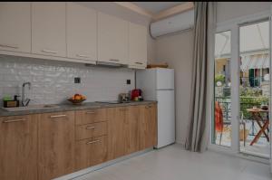 a kitchen with wooden cabinets and a white refrigerator at Dimitra Suites in Pythagoreio