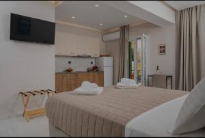 a bedroom with a large bed and a kitchen at Dimitra Suites in Pythagoreio