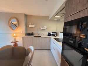 a kitchen with a microwave oven and a counter top at Escale élégante à la mer Duplex neuf en front de mer in Bénodet