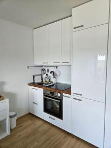 a kitchen with white cabinets and a stove at Apartment 416 mit Pool in Lahnstein