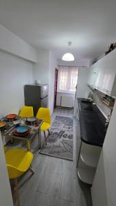 a kitchen with a table and yellow chairs in a room at Apartament Balto in Borsec +3 photos