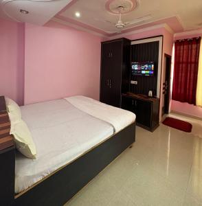 a bedroom with a bed and a tv in it at Pine View Guest House in Nāhan +6 photos