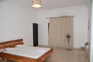 a bedroom with a bed and a chair in it at VILLA ÉKÉ Baguida plage in Baguida +37 photos