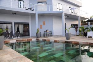 a swimming pool in front of a house at VILLA ÉKÉ Baguida plage in Baguida