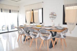 a dining room with a wooden table and chairs at VILLA ÉKÉ Baguida plage in Baguida