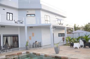 a white house with a swimming pool in front of it at VILLA ÉKÉ Baguida plage in Baguida