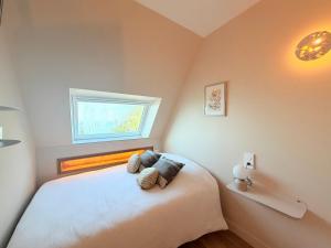 a bedroom with a white bed with a window at Escale élégante à la mer Duplex neuf en front de mer in Bénodet
