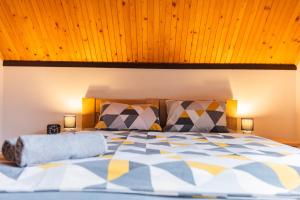 a bedroom with a large bed with a wooden ceiling at Penzion JAS in Zuberec
