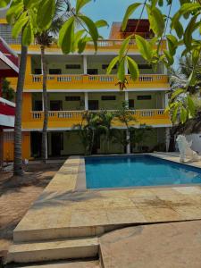 a hotel with a swimming pool in front of a building at La Muthu Beach Stay in Pondicherry +27 photos