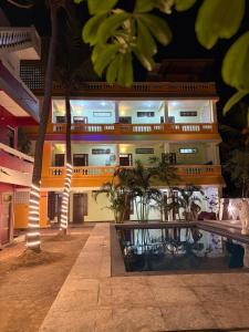 a building with palm trees in front of it at La Muthu Beach Stay in Pondicherry
