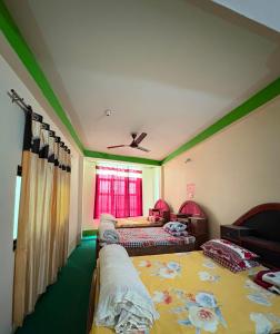 ein Schlafzimmer mit zwei Betten und einem Fenster in der Unterkunft Kasturi Hotel in Champapur + 2 Fotos