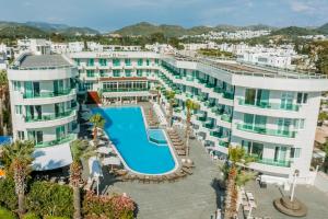 an aerial view of a hotel with a pool and palm trees at Dragut Point South Hotel-All Inclusive in Turgutreis