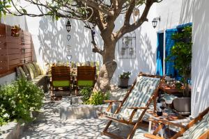 a patio with chairs and a tree and a table at Casa Maritina Gennadi Traditional House in Gennadi