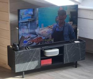 a tv on a tv stand with a flat screen at Finn Lodge in Saint-Denis-dʼOléron