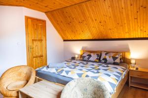 a bedroom with a bed and a wooden ceiling at Penzion JAS in Zuberec