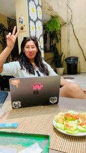 a woman sitting at a table with a laptop computer at Hostal Casa Margarito in Guadalajara