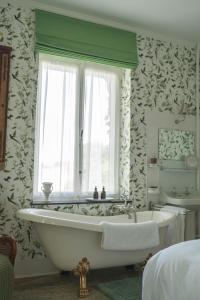 a bathroom with a tub and a window and a sink at Le Jardin des Roses Mons & Pairi Daiza proches in Dour