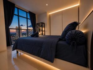 a bedroom with a blue bed with a large window at ETERNITY FORMOSA 2BR BALCONY 76m2 in Jodoh
