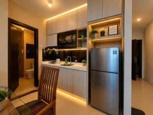 a kitchen with a stainless steel refrigerator and a sink at ETERNITY FORMOSA 2BR BALCONY 76m2 in Jodoh