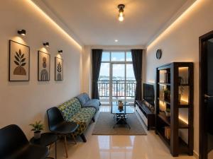 a living room with a couch and a television at ETERNITY FORMOSA 2BR BALCONY 76m2 in Jodoh