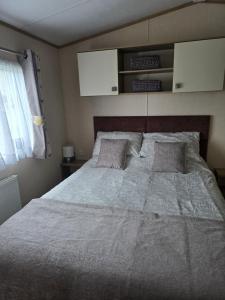 a bedroom with a large bed with two pillows at Bayview at Pengarreg in Llanrhystyd