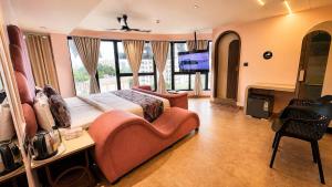 ein Schlafzimmer mit einem großen Bett, einer Couch und einem Fernseher in der Unterkunft Hotel Nova Bling in Rajkot