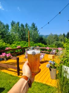 a person holding up a glass of beer at Czarna Owca in Istebna +173 photos