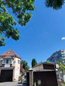 a house with a gate in front of a building at Dlya Vseh Motel in Kamianets-Podilskyi