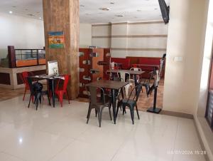 a dining room with tables and chairs in a restaurant at Legenda Beril Hostel in Makassar