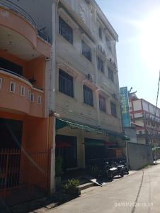 a tall building with a street in front of it at Legenda Beril Hostel in Makassar