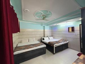 a room with two beds and a ceiling at Pine View Guest House in Nāhan