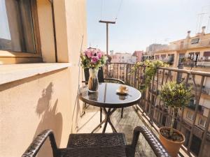 a table and chairs on a balcony with a vase of flowers at Tra Terra e Laguna in Venice