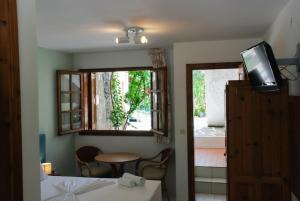ein Zimmer mit einem Bett, einem Fernseher und einem Fenster in der Unterkunft Kipos Hotel in Limenas