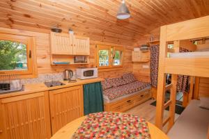 a kitchen with a bed in a wooden cabin at Camping Onlycamp du Rouergue in Villefranche-de-Rouergue +42 photos