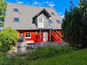 a red house with a black roof and a window at Ferienhaus Hutznhaisl in Bärenstein