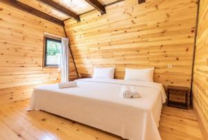 a bedroom in a log cabin with a bed at Hatsvali Gate in Mestia