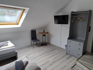 a room with a bedroom with a bed and a tv at Landhotel Laarmann in Lennestadt