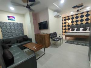 a living room with a couch and a bed at Hotel Abhijeet Inn in Raipur