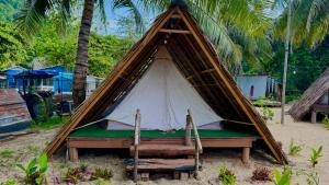 a teepee tent on the beach with a chair at Long Beach Camp in Perhentian Islands