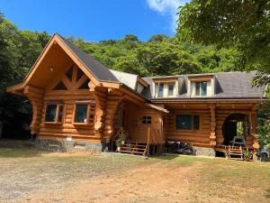 a log home with a gambrel roof at PrivateVillaHutamiLog in Nago