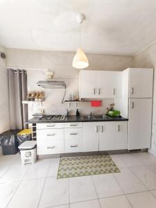a white kitchen with white cabinets and a sink at Tra Terra e Laguna in Venice