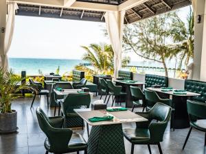 a restaurant with tables and chairs and the ocean at Apsara Resort Koh Rong in Koh Rong Island