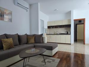 a living room with a couch and a table and a kitchen at Apartments Bujkovic in Bar