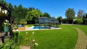 a glass house with a pool in a yard at Gite oncle Yerry in Ostheim