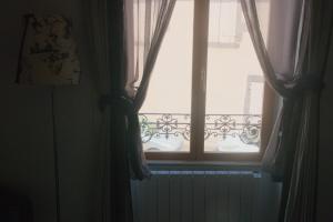 a window with curtains and a radiator in a room at Maison Entière à Cébazat in Cébazat