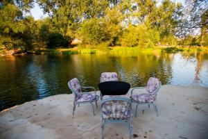 a table and four chairs sitting in front of a lake at Private Riverside Villa Silvia in Mostar