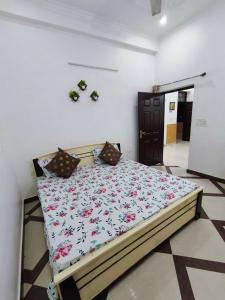 a bedroom with a bed with a floral comforter at Comfy Stay in Dehradun