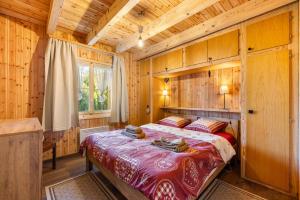 a bedroom with a bed in a wooden room at Darjean - 8 pers - belle vue in Plan Fey