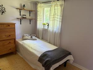 a small bedroom with a bed and a window at Höga kusten Berghamn in Noraström