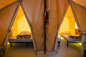 a room with three beds in a tent at Camping Onlycamp du Rouergue in Villefranche-de-Rouergue